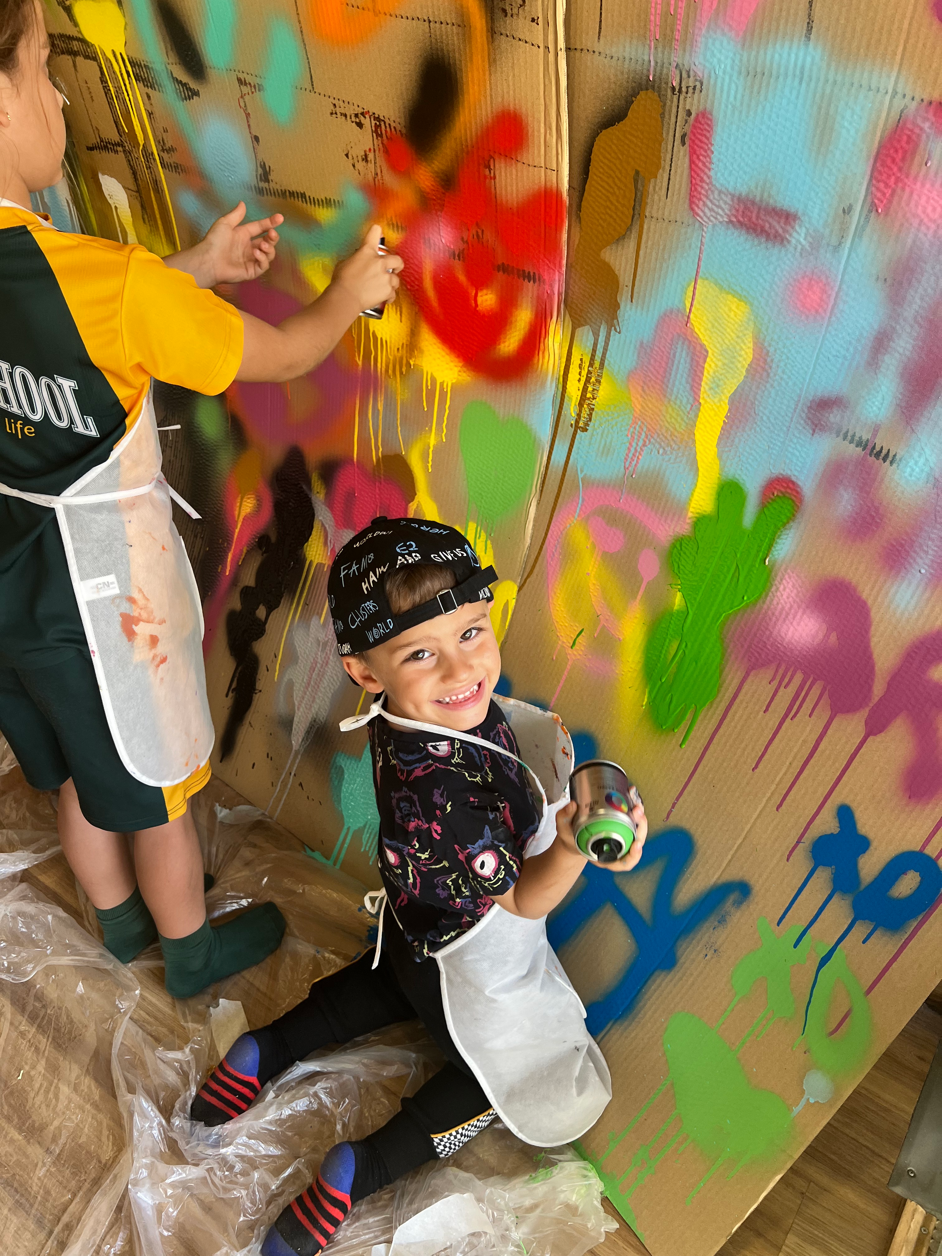Un niño pintando un graffiti con spray no tóxico