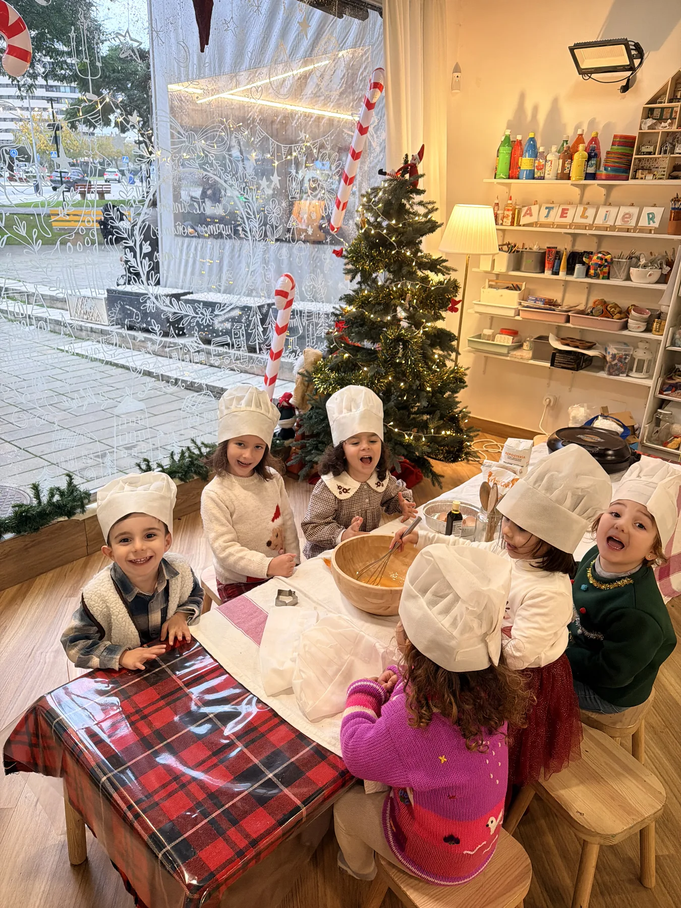 Grupo de peques cocinando juntos en el campamento de Navidad